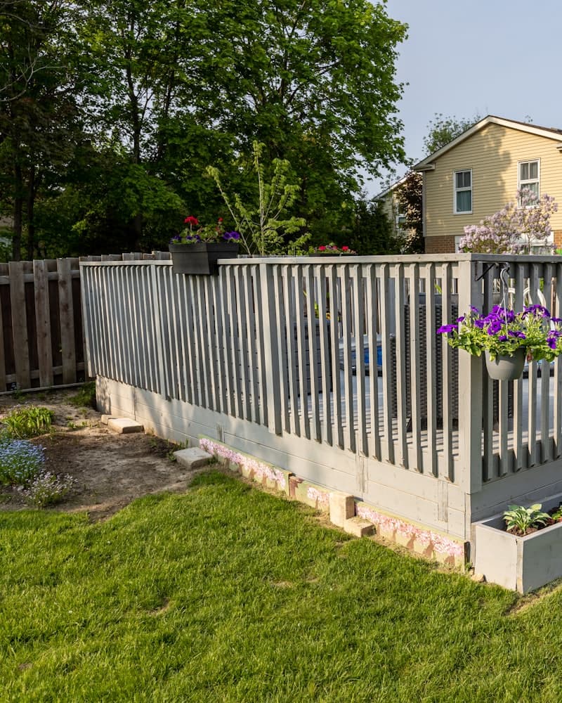 A white picket fence running along a residential front yard
