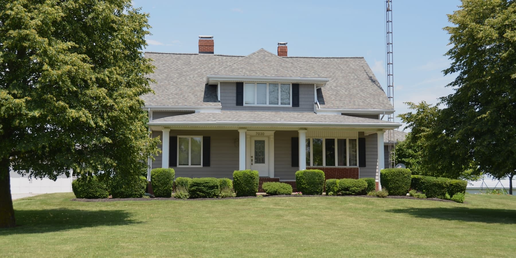 A classic white two-story home with a wide front lawn